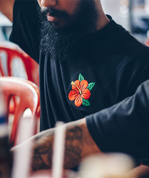 custom embroidery of a flower on the AS Colour Heavy Tee in Black