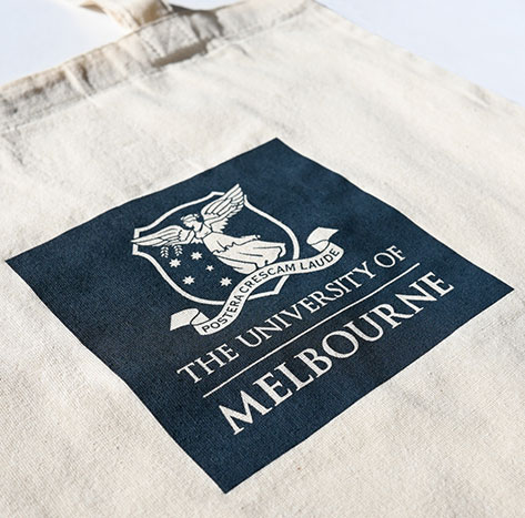 Custom Calico Tote Bags in Natural screen printed with the University Of Melbourne Logo in Navy Plastisol ink