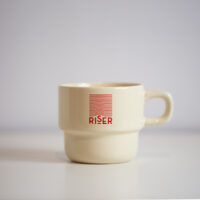 ceramic mug in cream printed with Riser logo in red