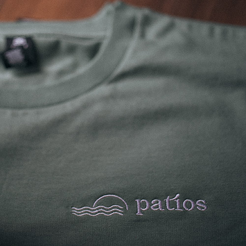 Custom Embroidery - T-Shirts - Patios Logo in white thread on AS Colour Staple Tee in Sage