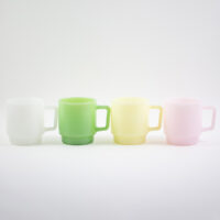 Collection of custom milk glass mugs in white, jade green, yellow, and soft pink