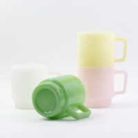 Green milk glass mug showcasing the base design alongside a pastel stackable collection
